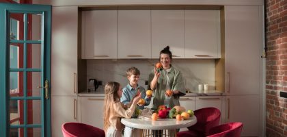 Mother with children preparing meals with fresh ingredients in a modern kitchen.