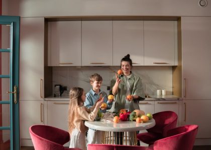 Mother with children preparing meals with fresh ingredients in a modern kitchen.