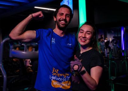 Happy couple in sportswear posing confidently at a gym, showing fitness enthusiasm.